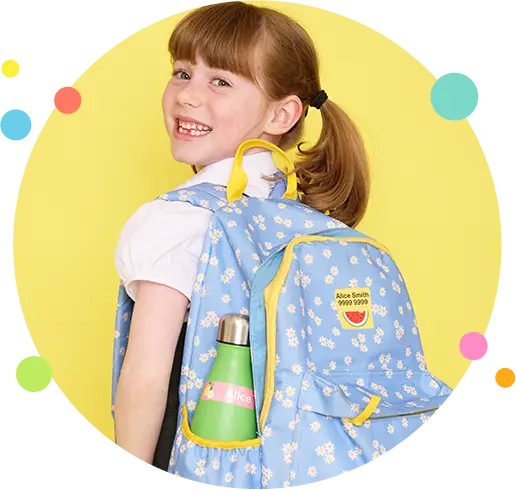 schoolgirl smiling with her labelled backpack