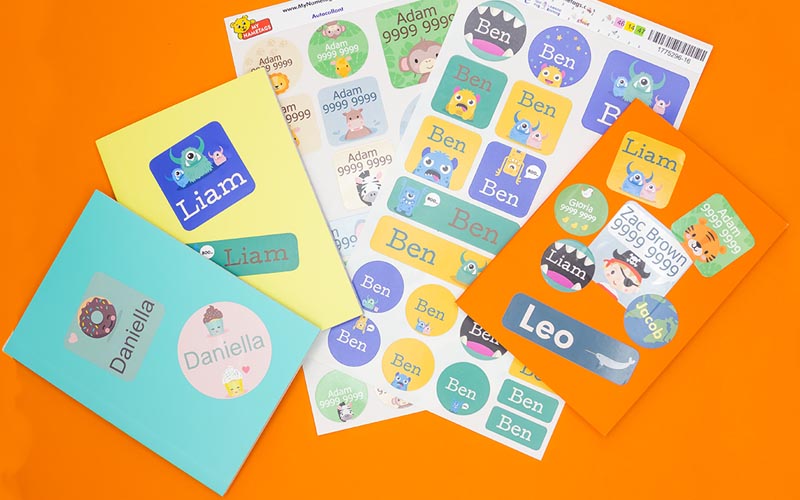Personalised name stickers on books on an orange background